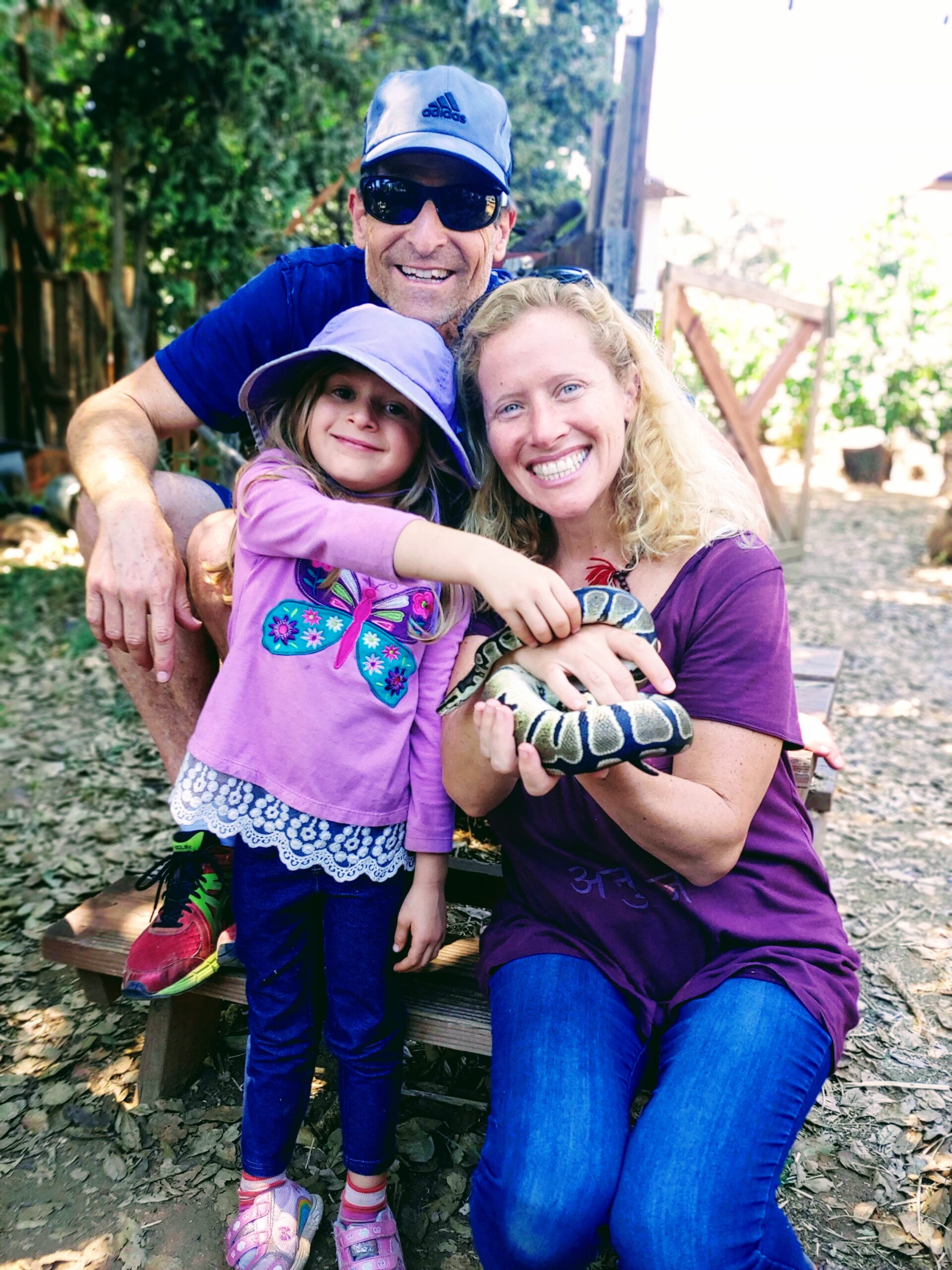Mom dad & daughter petting a snake photo