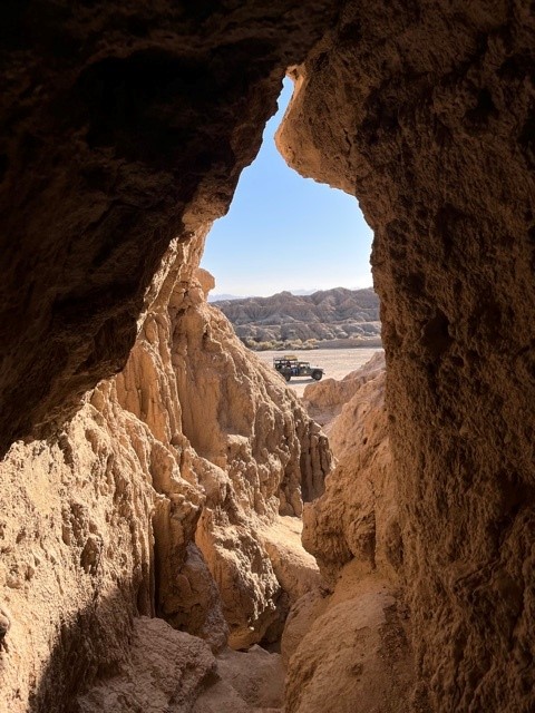 California Overland Desert Excursions looking from inside a cave out at a jeep