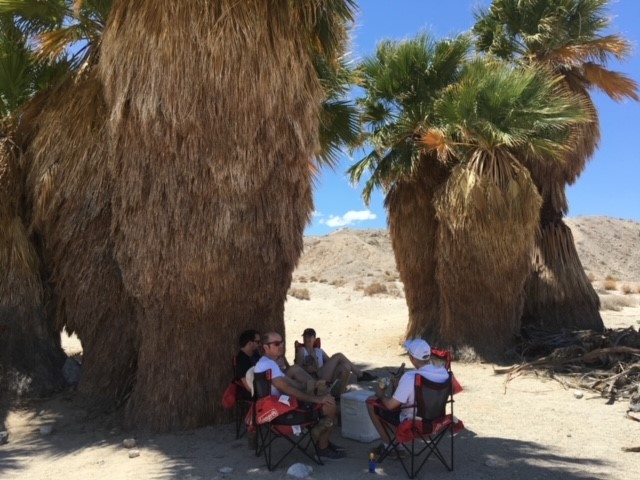 California Overland Desert Excursions People sitting under palm trees photo
